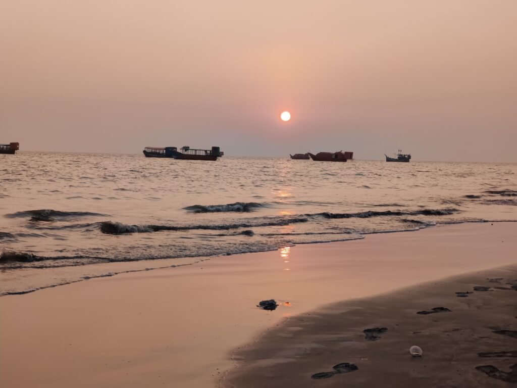 Sunset over Chandipur beach with fishing boats anchored offshore | Family Tour Packages in Odisha - A guide by Immersive Trips