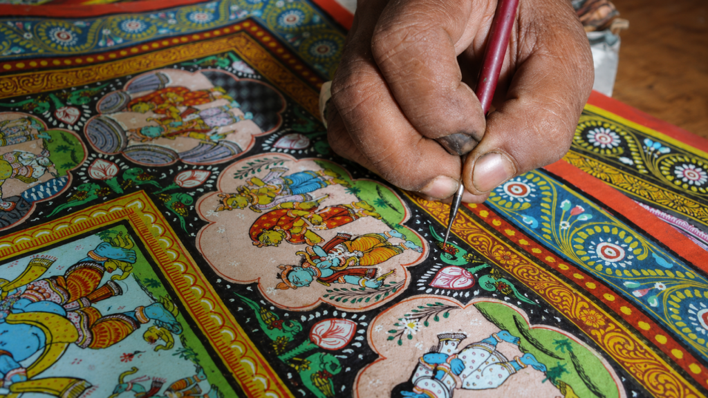 Artisan hand painting a Pattachitra artwork at Ekamra Haat