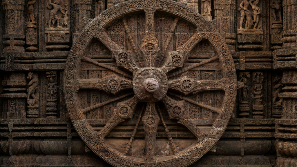 Carved stone chariot wheel on the wall of the Konark Sun Temple, a highlight of Odisha tour packages