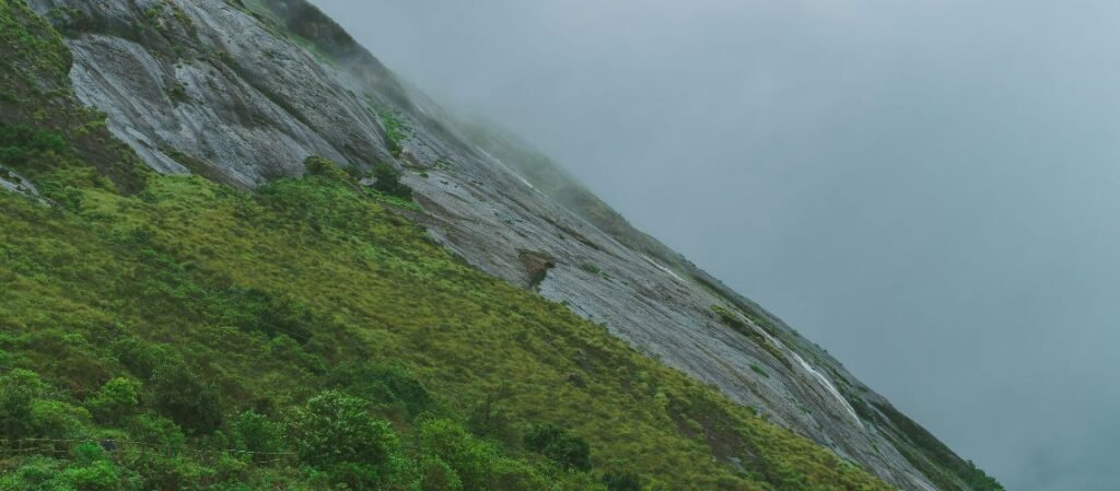 The misty, steep rocky slopes of Eravikulam National Park in the Western Ghats near Munnar, Kerala, India.