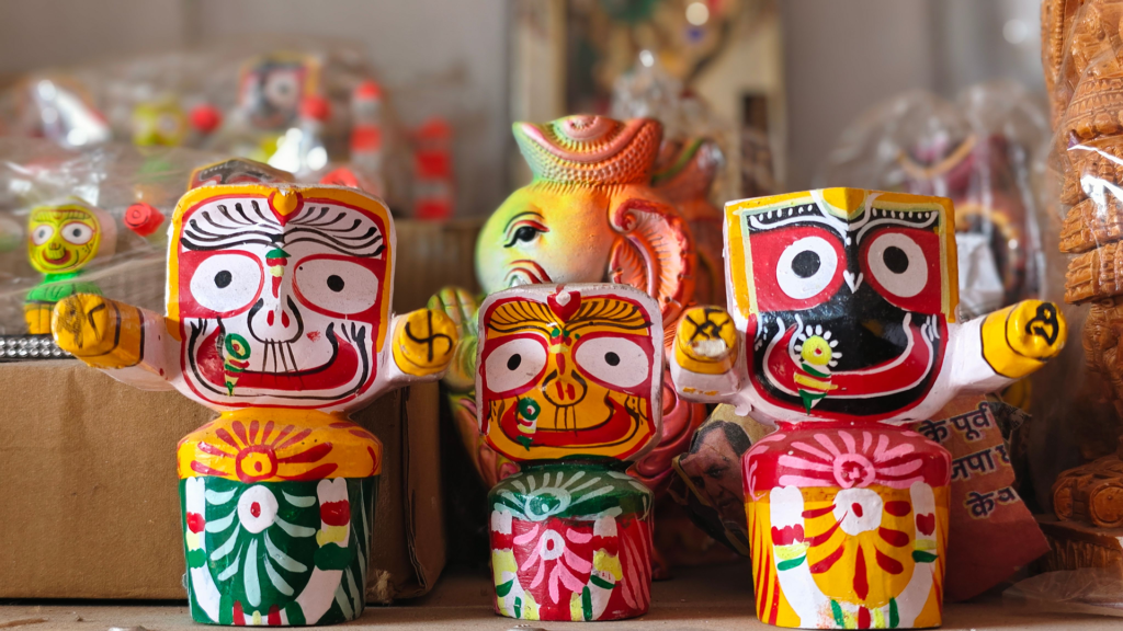 Hand-painted wooden figurines of Balabhadra, Subhadra and Jagannath sold in a Puri craft shop during travel to Odisha
