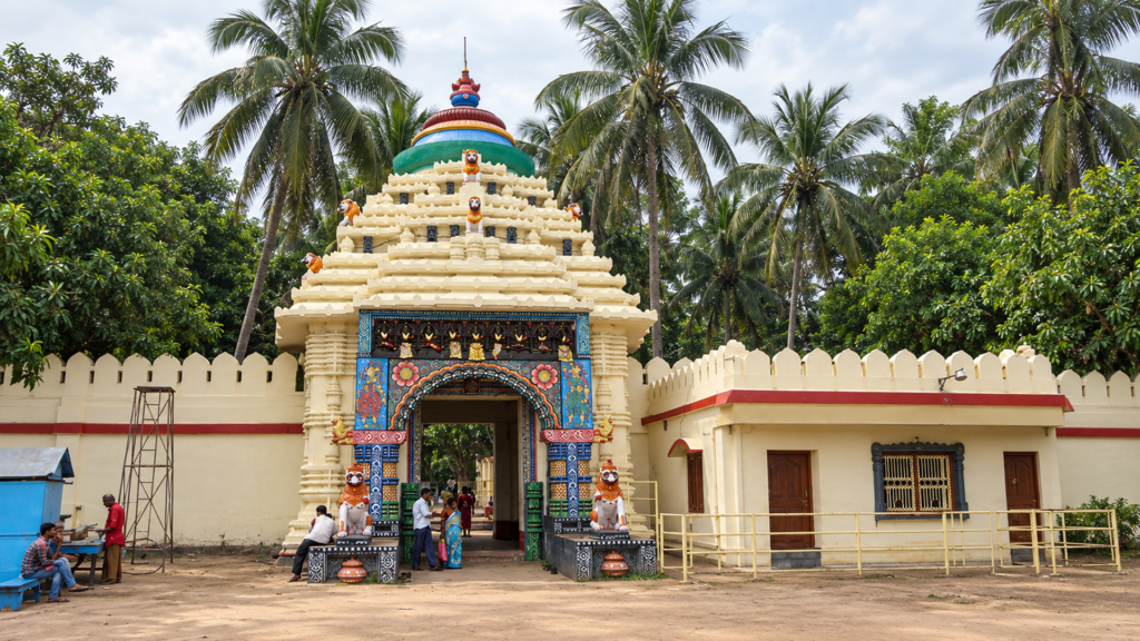 A colourful temple gateway lined with palm trees, one of Puri's smaller shrines near the main pilgrim circuit : Best Places to Visit in Puri