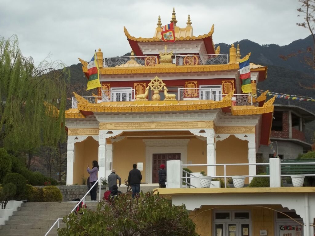 A Complete Dharamshala Travel Guide for First-Time Visitors 1 Tibetan Buddhist monastery in Dharamshala with traditional golden architecture and prayer flags against a mountain backdrop.